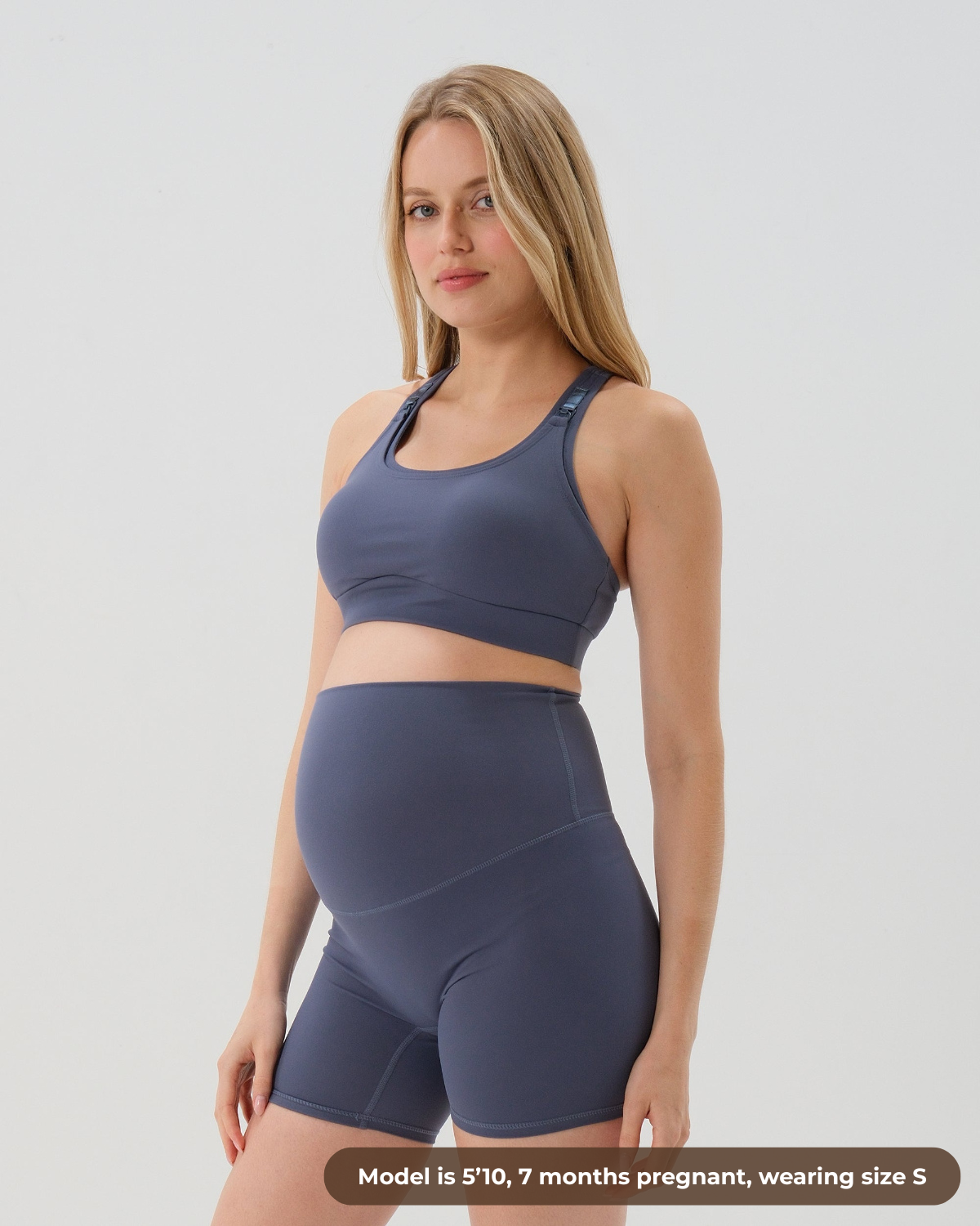 Pregnant woman wearing premium blue high-impact, racerback maternity and nursing sports bra, with matching light gray maternity legging in a stylish set. Premium maternity athletic and activewear by AXK - high quality petite, tall, and plus size maternity.