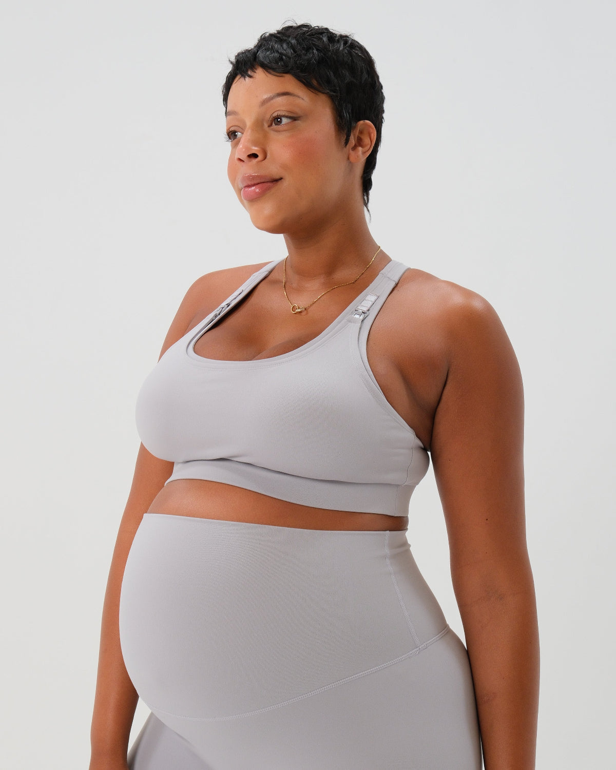 Pregnant woman wearing premium light gray high-impact, racerback maternity and nursing sports bra, with matching light gray maternity legging in a stylish set. Premium maternity athletic and activewear by AXK - high quality petite, tall, and plus size maternity.