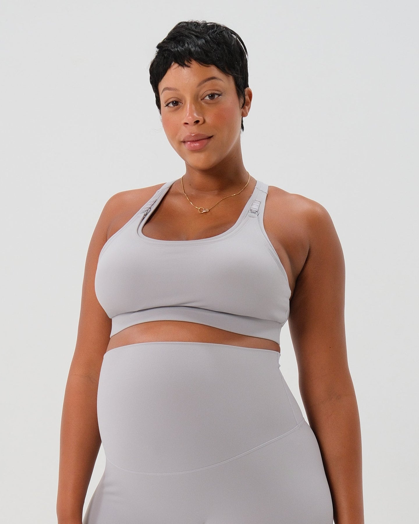 Pregnant plus size woman wearing premium light gray high-impact, racerback maternity and nursing sports bra, with matching light gray maternity legging in a stylish set. Premium maternity athletic and activewear by AXK - high quality petite, tall, and plus size maternity.