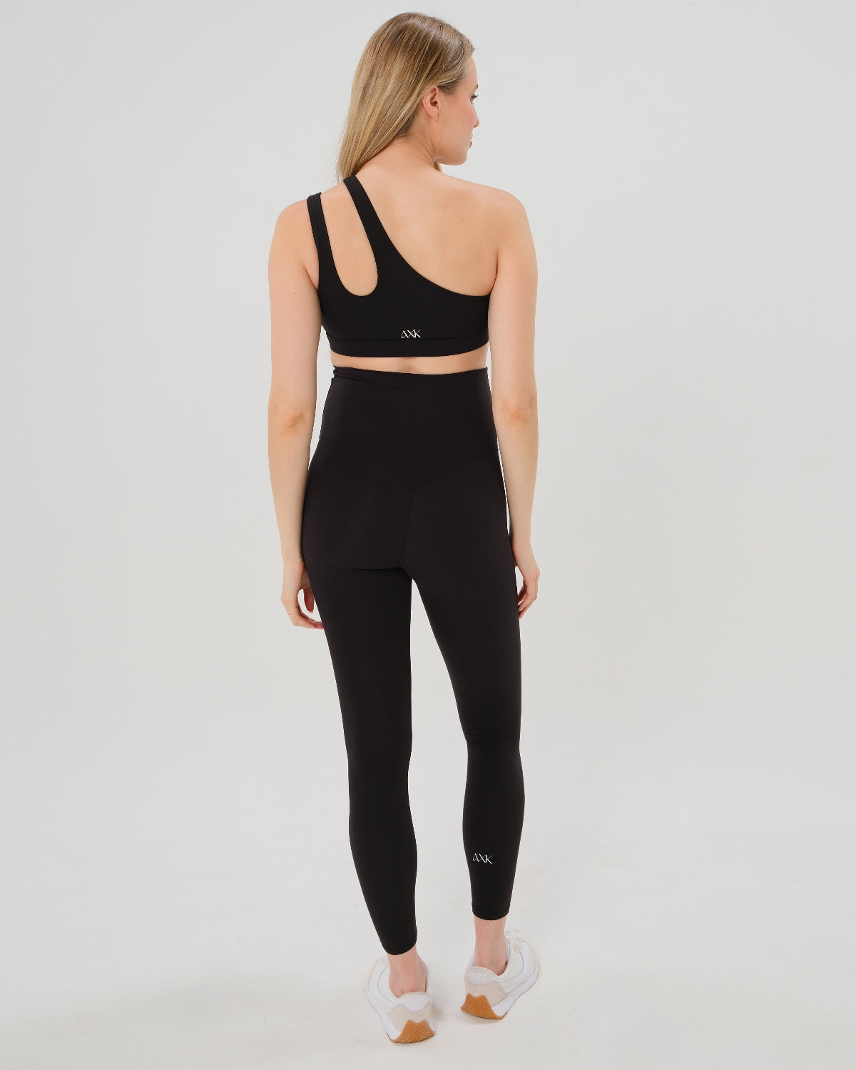 Pregnant woman wearing our best reviewed AXK premium black maternity leggings for 2026 with a matching trendy one shoulder nursing sports bra. Premium maternity athletic and activewear by AXK, available in plus sizes. Petite and tall friendly. 