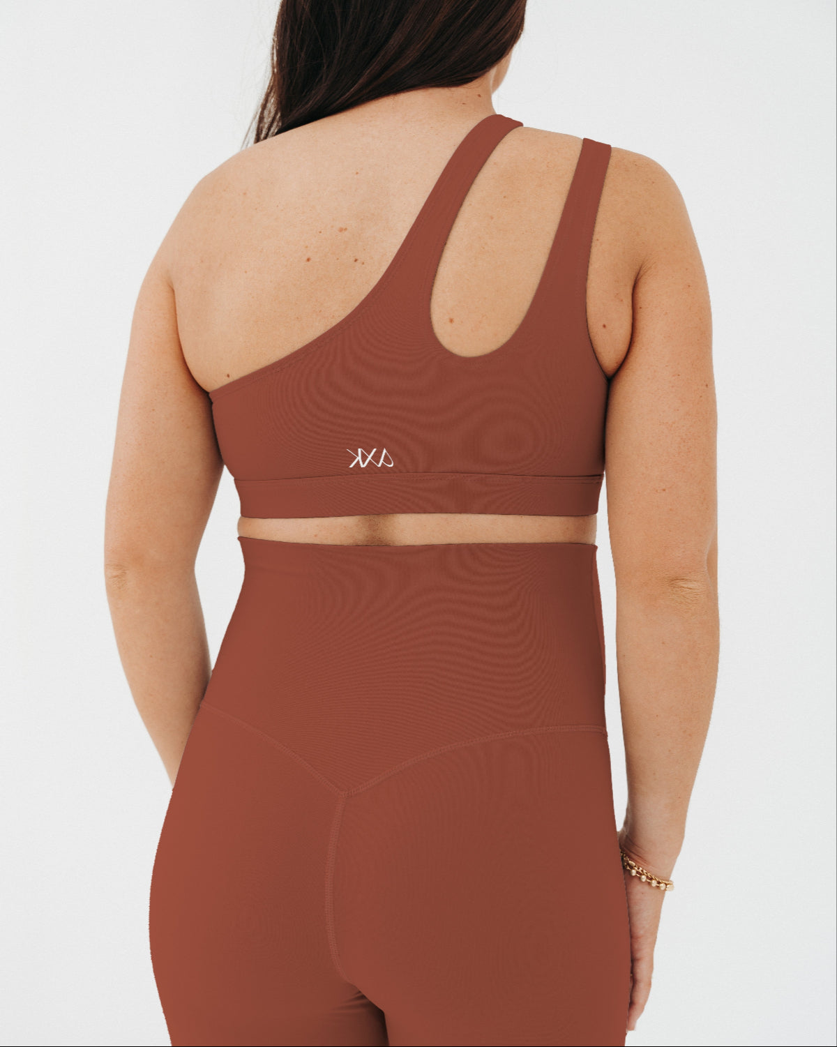 Brown AXK one-shoulder maternity and nursing sports bra. Paired with matching high-waist leggings, this premium maternity workout set is available in plus size, tall friendly, and petite friendly sizing. Premium maternity activewear and athleisure by AXK.