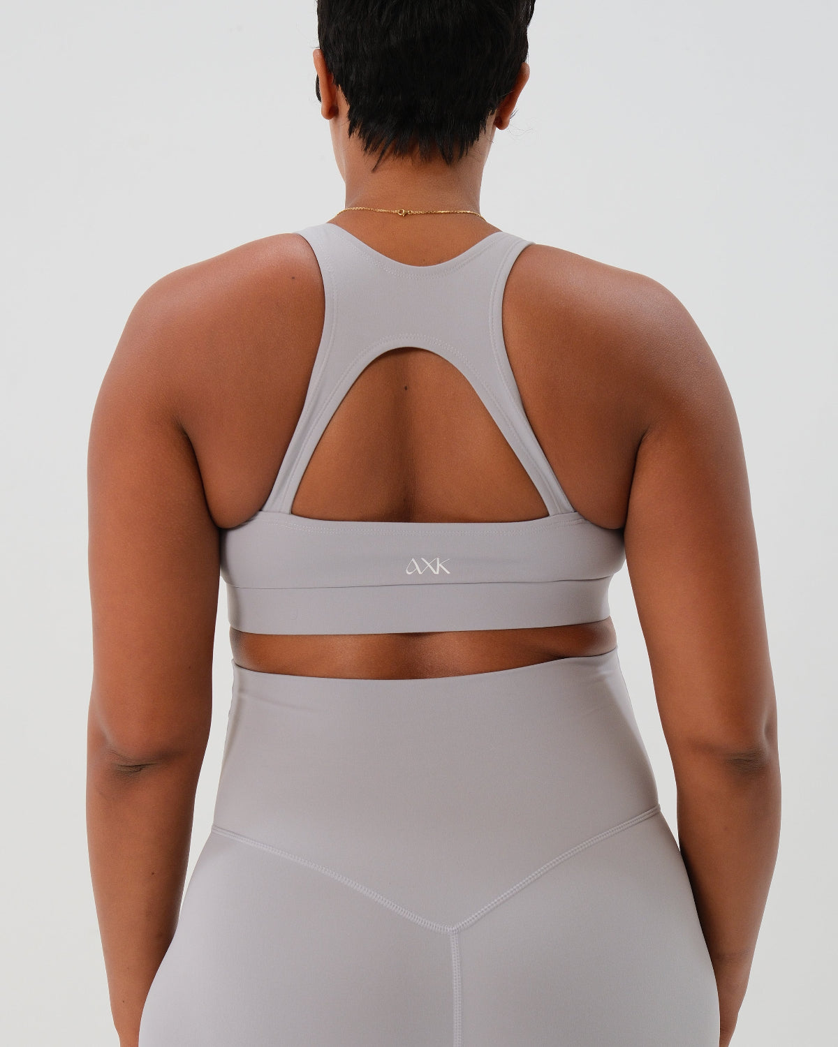 Pregnant woman wearing premium light gray high-impact, racerback maternity and nursing sports bra, with matching light gray maternity legging in a stylish set. Premium maternity athletic and activewear by AXK - high quality petite, tall, and plus size maternity. 